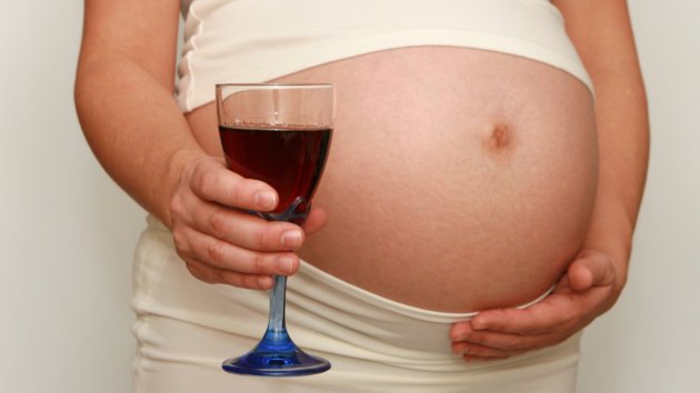 Pregnant woman with glass of red wine.