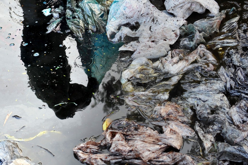 An Indian worker washing plastics is reflected in a pool of liquid at a dump on the outskirts of Mumbai on December 11, 2009. India like other emerging world economies is under pressure to make a gesture during the ongoing Copenhagen climate summit. India's per capita greenhouse gas emissions are expected to nearly triple in the next two decades from about 1.2 tonnes per person per year to 2.1 tonnes in 2020 and 3.5 tonnes in 2030, according to a recent government-backed report, which is still below the global average of 4.2 tonnes per person. But India's massive 1.1-billion population puts the country among the world's leading greenhouse gas emitters. AFP PHOTO/ Pal PILLAI (Photo credit should read PAL PILLAI/AFP/Getty Images)