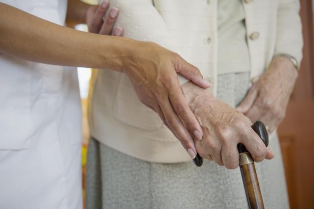 Close-up-of-carer-helping-older-woman-walk