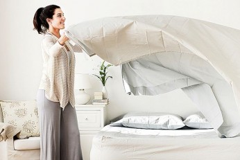 Woman-changing-bedsheets
