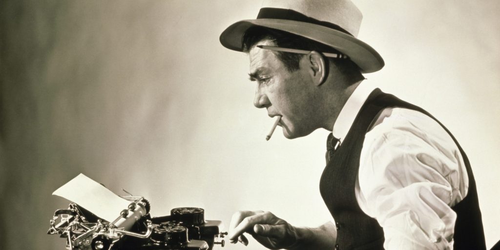 Side profile of a journalist typing on a typewriter