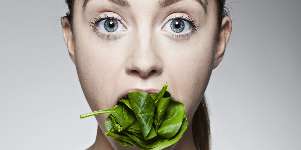 Woman with mouthful of lettuce