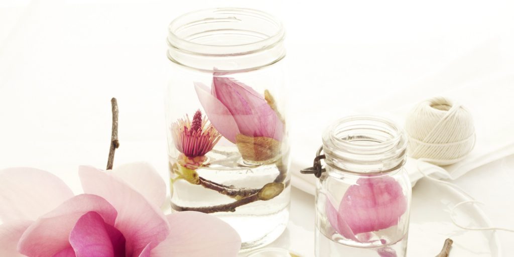 Home still life pink magnolia flowers in glass mason jars