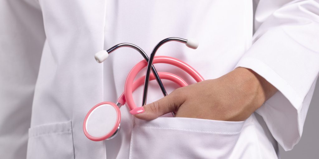Feminine doctor with pink stethoscope in pocket