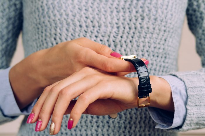 47175277 - female hands with a bright manicure dress watch on wrist.
