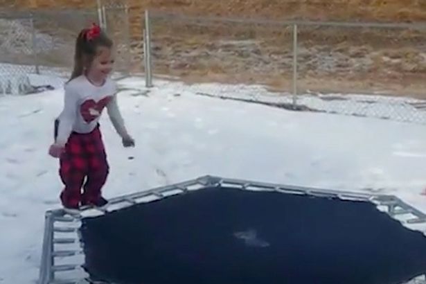 little-girl-bouncing-on-an-ice-covered-trampoline