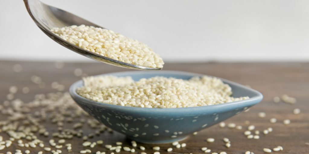 Close up of spoon of overflowing sesame seeds