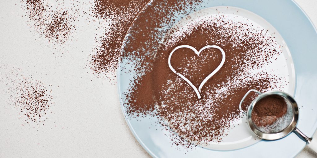 Heart-shape drawn into cocoa powder on plate